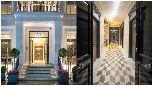 Entrance portico with square columns framing black double entrance doors that lead to the entrance hall with decorative feature ceiling lighting & chequered floor with dark six panelled doors flanking the hall