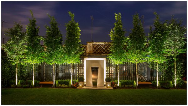 Garden landscaping with integrated seating areas and backlit ornamental water feature, incorporating the original scalloped garden wall